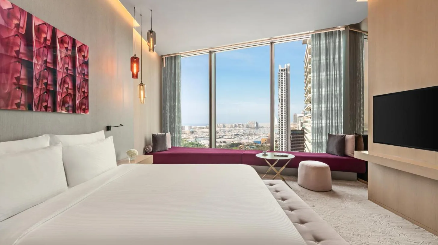 a bedroom with a large white bed and a tv at Rixos Premium Dubai JBR in Dubai