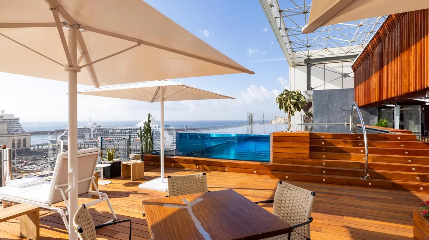 un patio avec une table et des chaises et une piscine au ROMEO Napoli Ã  Naples