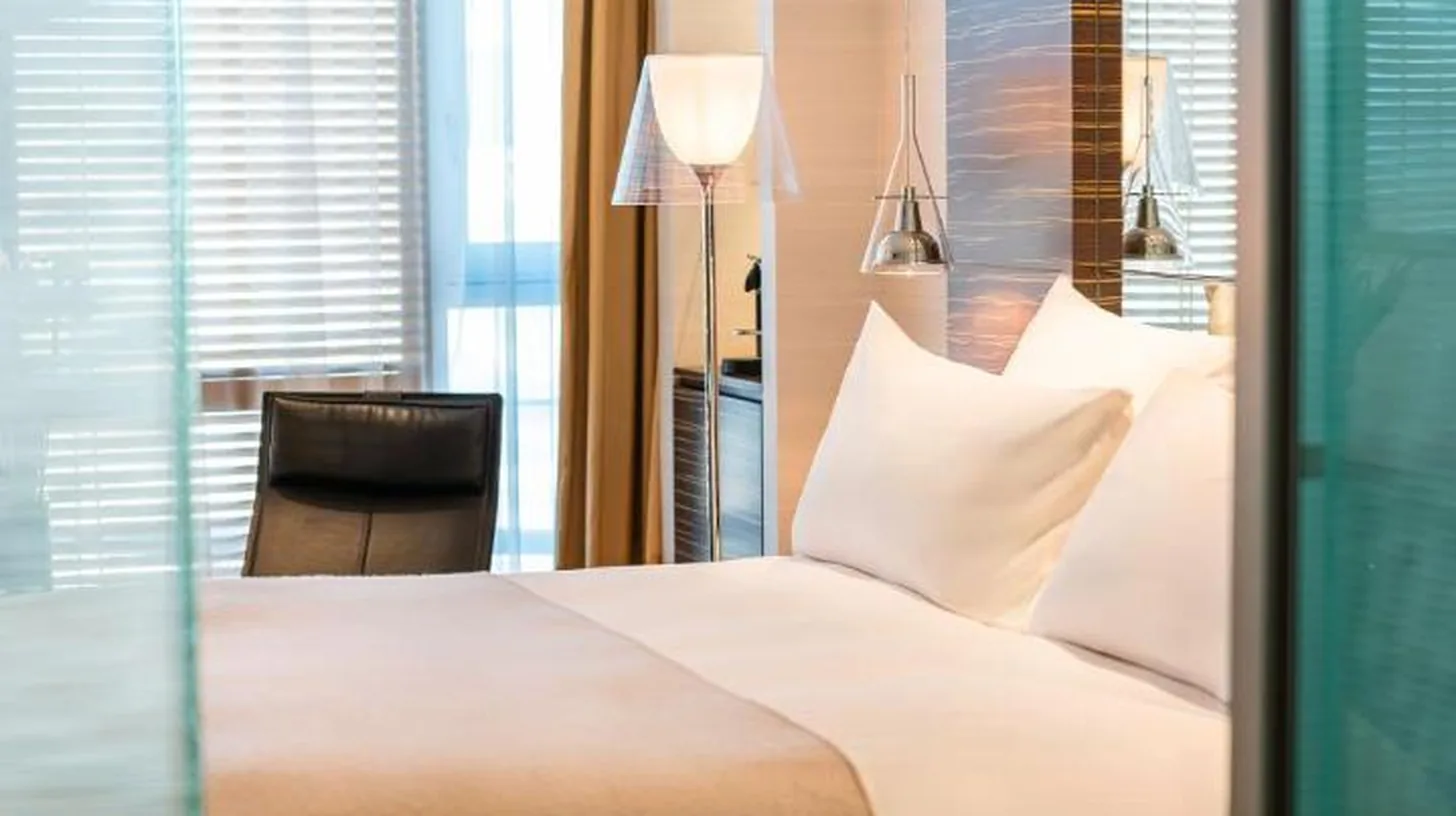 une chambre avec un grand lit blanc et un bureau au ROMEO Napoli Ã  Naples
