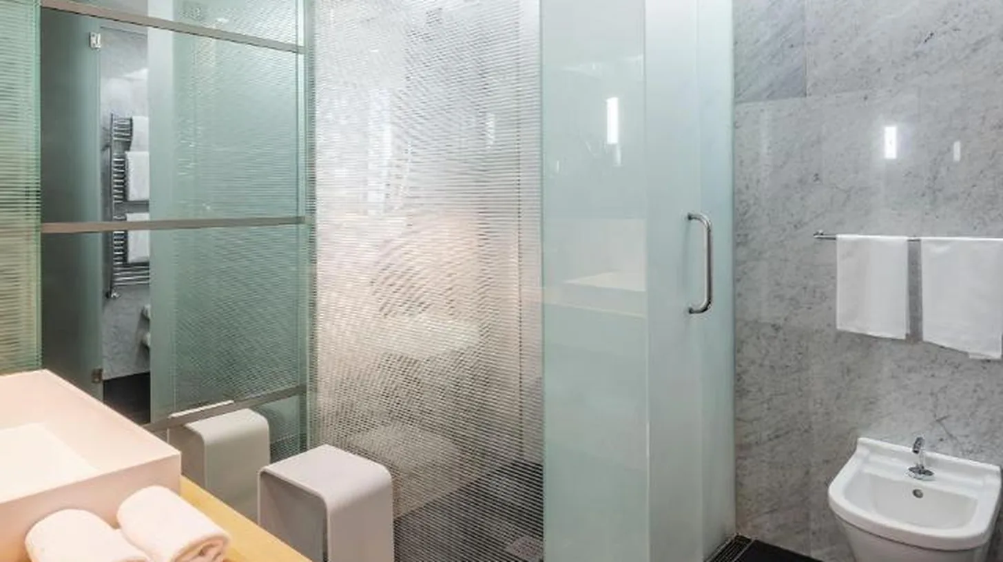 une salle de bain avec une douche en verre et des toilettes au ROMEO Napoli Ã  Naples