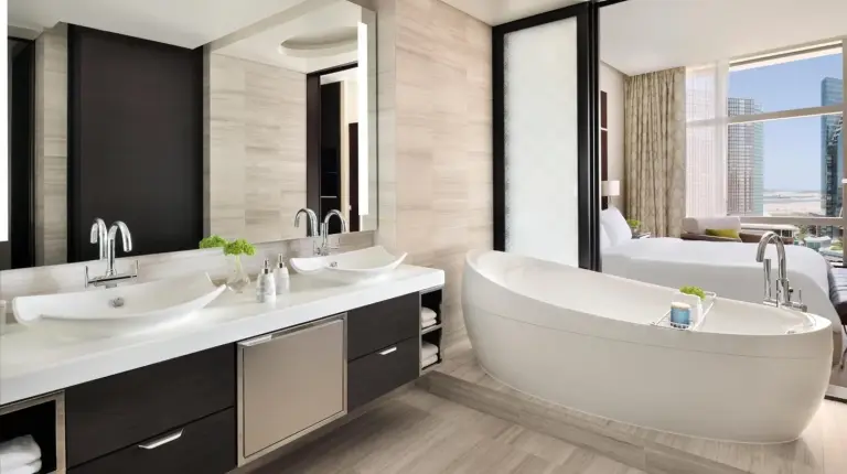 a bathroom with two sinks and a bath tub at Rosewood Abu Dhabi in Abu Dhabi