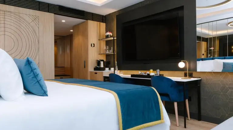 une chambre avec un lit, un bureau et une télévision au Royal Hideaway Casablanca à Casablanca