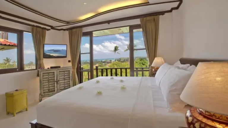 a bedroom with a bed and a balcony with a television at Royal Majestic Grand Thai Villa in Choeng Mon Beach