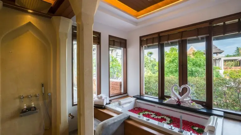 a bedroom with a large bed with a table on it at Royal Muang Samui Villas in Choeng Mon Beach