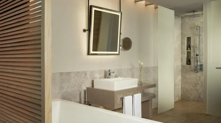 a bathroom with a tub and a sink and a mirror at Saadiyat Rotana Resort and Villas in Abu Dhabi