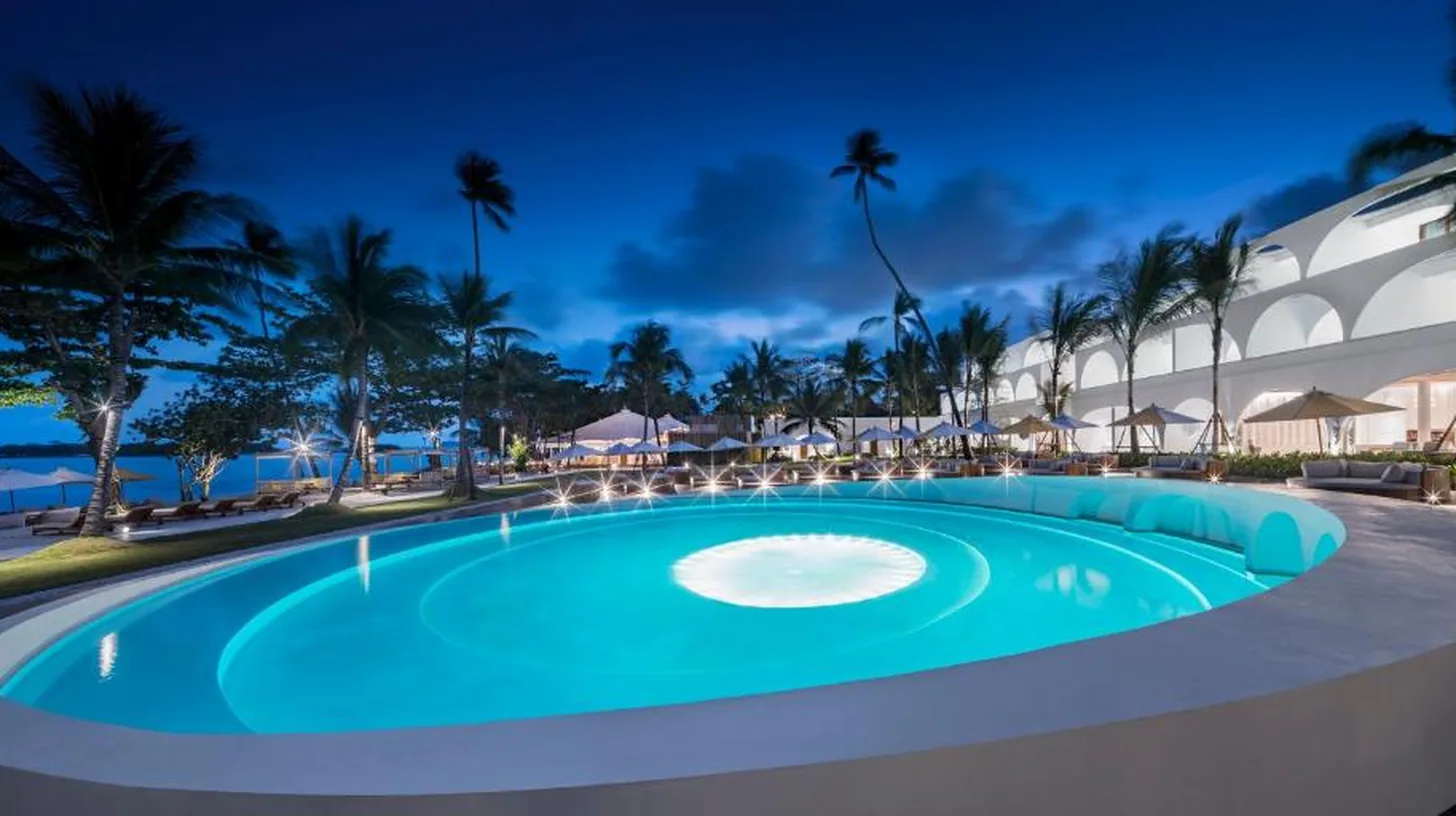 a swimming pool in a resort at night at SALA Samui Chaweng Beach Resort in Chaweng