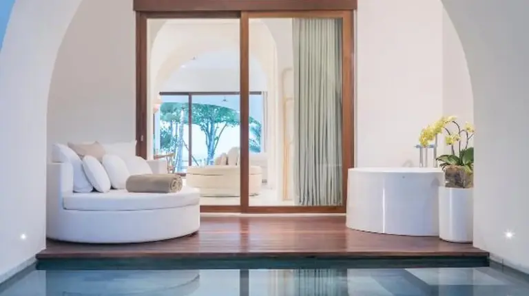 a living room with a white couch and a pool at SALA Samui Chaweng Beach Resort in Chaweng