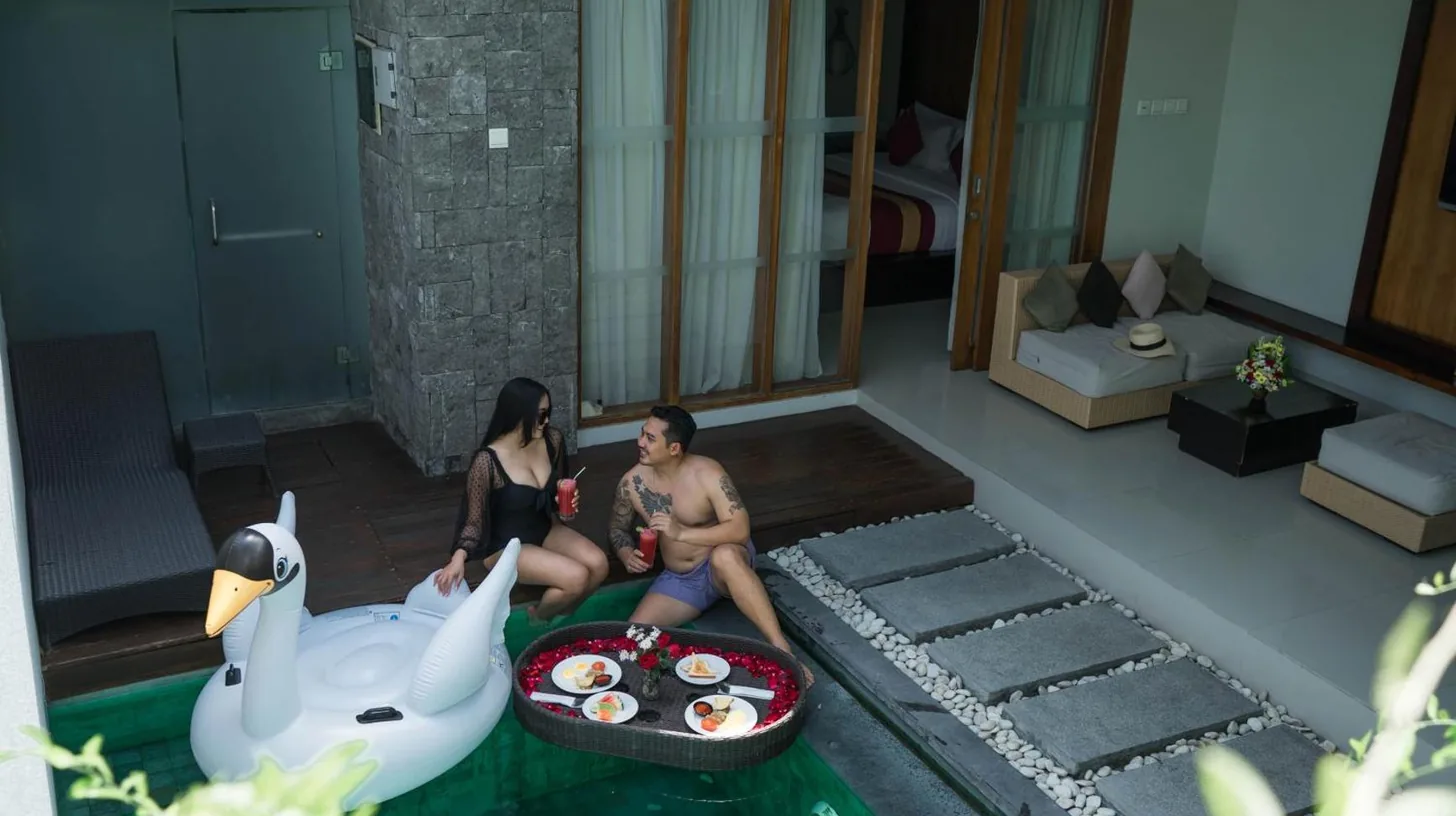 ein Mann und eine Frau sitzen auf einem falschen Schwanenboot bei Samaja Villas Seminyak in Seminyak