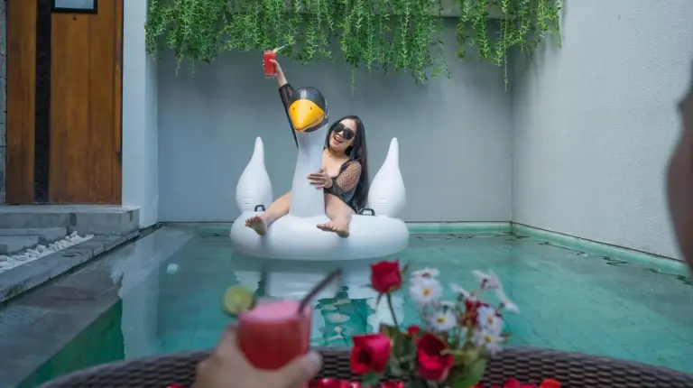 eine Frau sitzt auf einem Einhorn im Pool bei Samaja Villas Seminyak in Seminyak