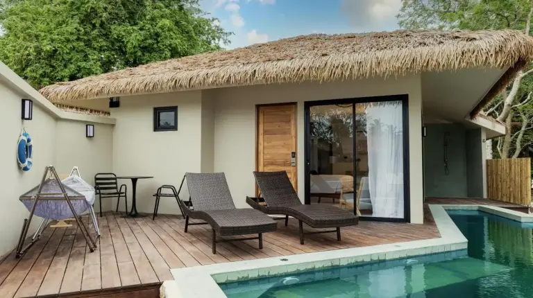 a house with a thatched roof and a swimming pool at Samaraya Wellness Resort - Adults Only in Lipa Noi