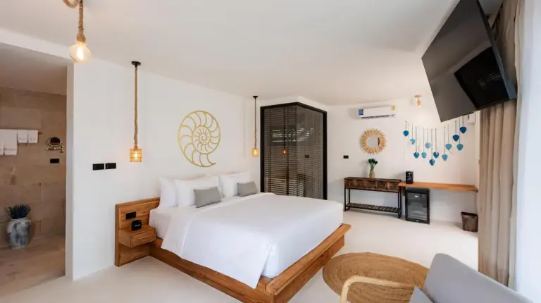 a bedroom with a large white bed and a flat screen tv at Samaraya Wellness Resort - Adults Only in Lipa Noi