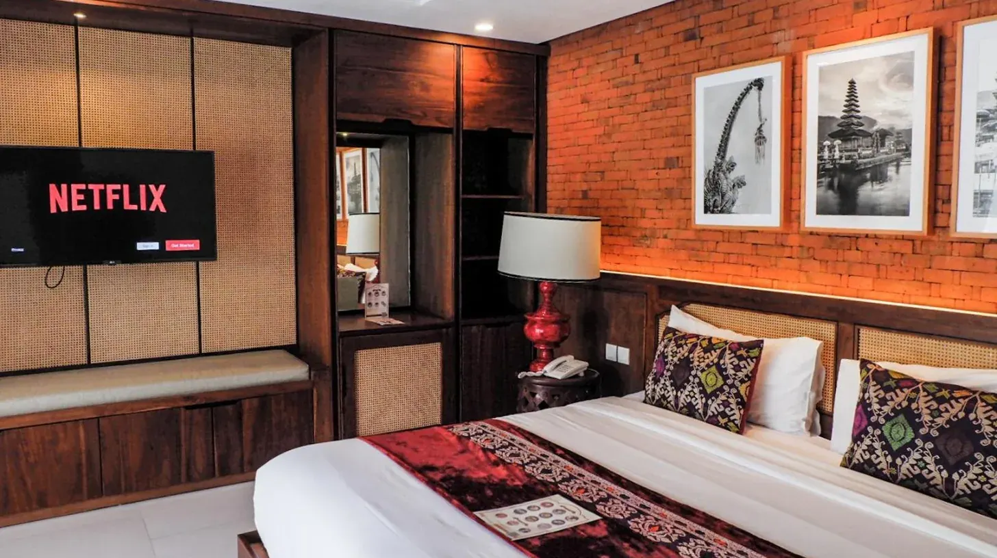 una habitación de hotel con una cama y un televisor en Sampatti Villas en Seminyak