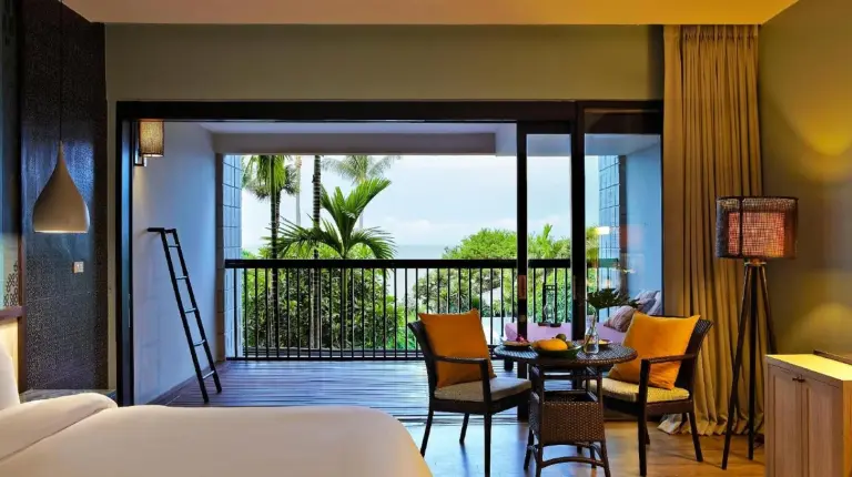 a bedroom with a bed and a balcony with a table and chairs at Sareeraya Villas & Suites in Chaweng
