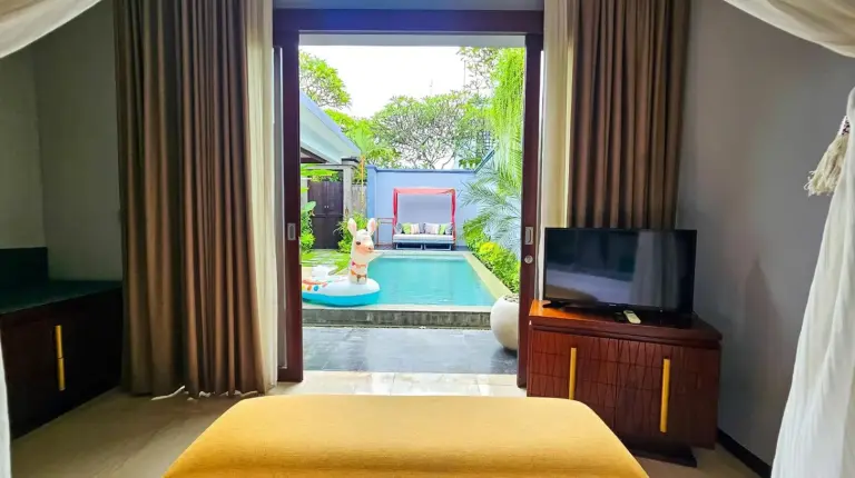 un dormitorio con un televisor y una piscina en Seminyak Icon - by Karaniya Experience - CHSE certified en Seminyak