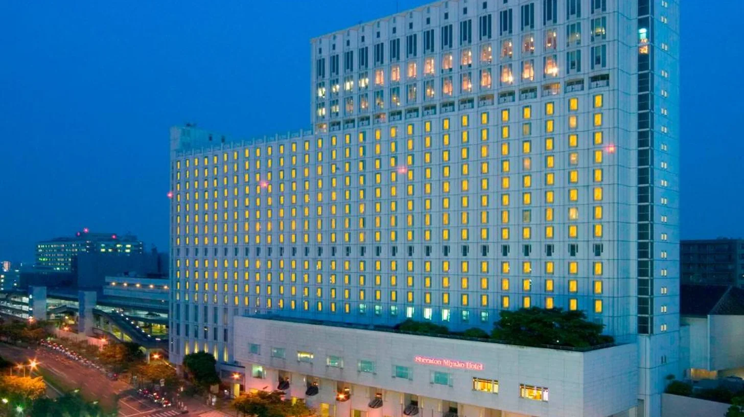 a large building with lights on in a city at night at Sheraton Miyako Hotel Osaka in Osaka