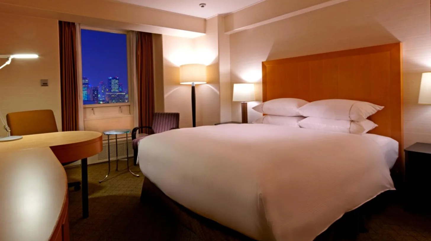 a large white bed in a hotel room with a window at Sheraton Miyako Hotel Osaka in Osaka