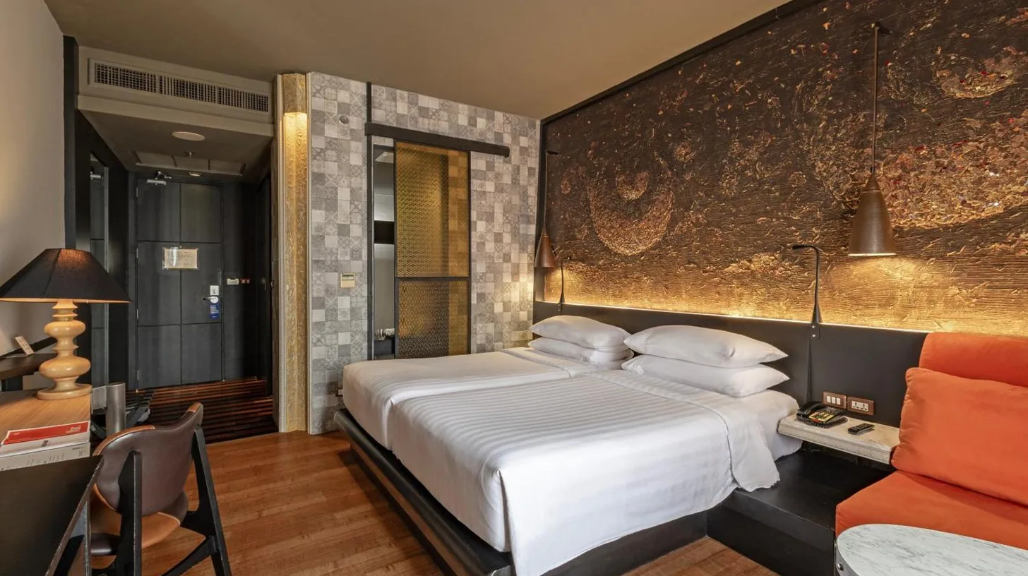 a bedroom with a large white bed and a table at Siam At Siam Design Hotel Bangkok in Bangkok