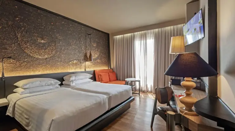 a hotel room with a large bed and a desk at Siam At Siam Design Hotel Bangkok in Bangkok