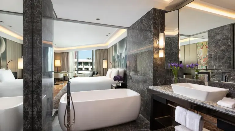 a bathroom with a tub and a sink and a shower at Siam Kempinski Hotel Bangkok in Bangkok