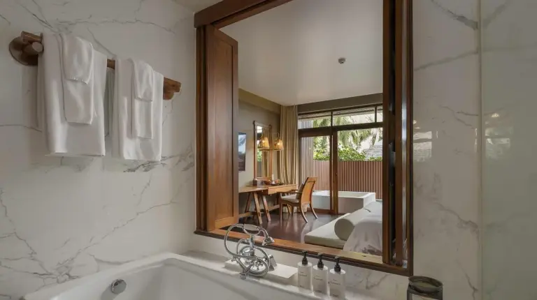 a bathroom with a tub and a large mirror at Silavadee Pool Spa Resort - SHA Extra Plus in Lamai
