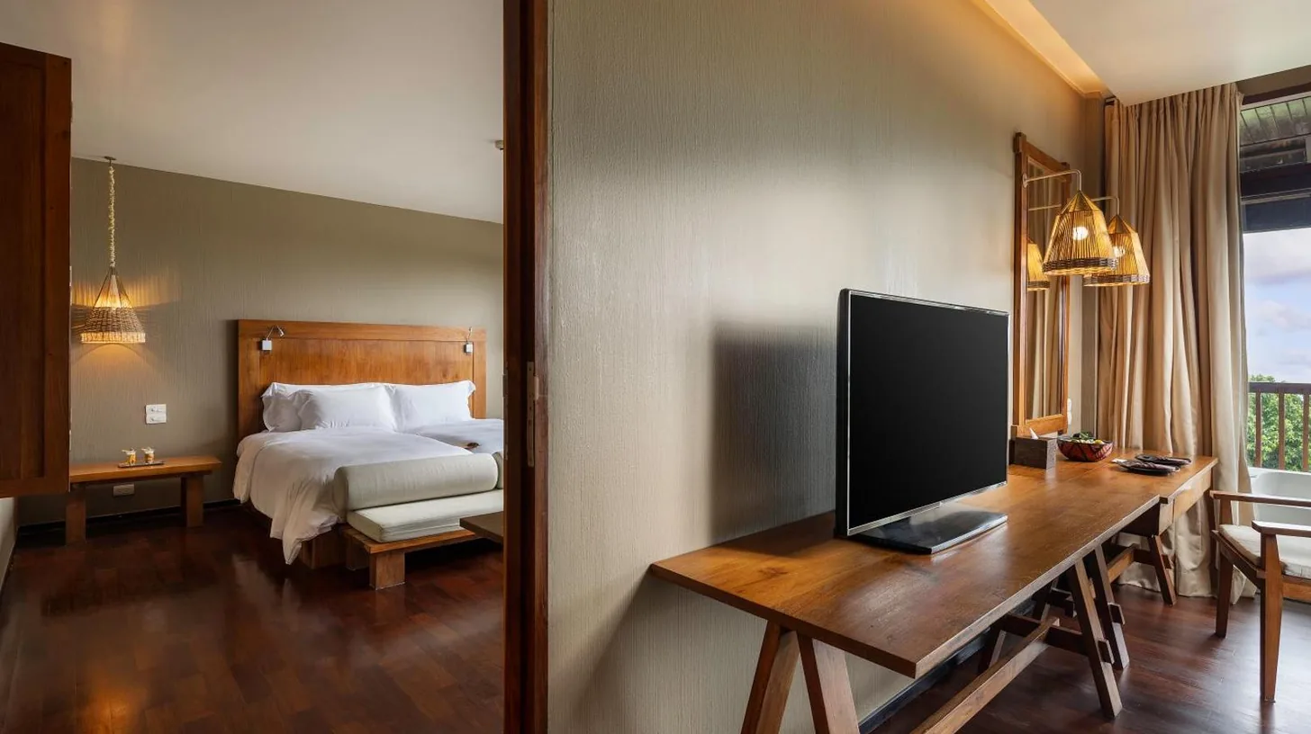 a bedroom with a bed and a flat screen tv at Silavadee Pool Spa Resort - SHA Extra Plus in Lamai