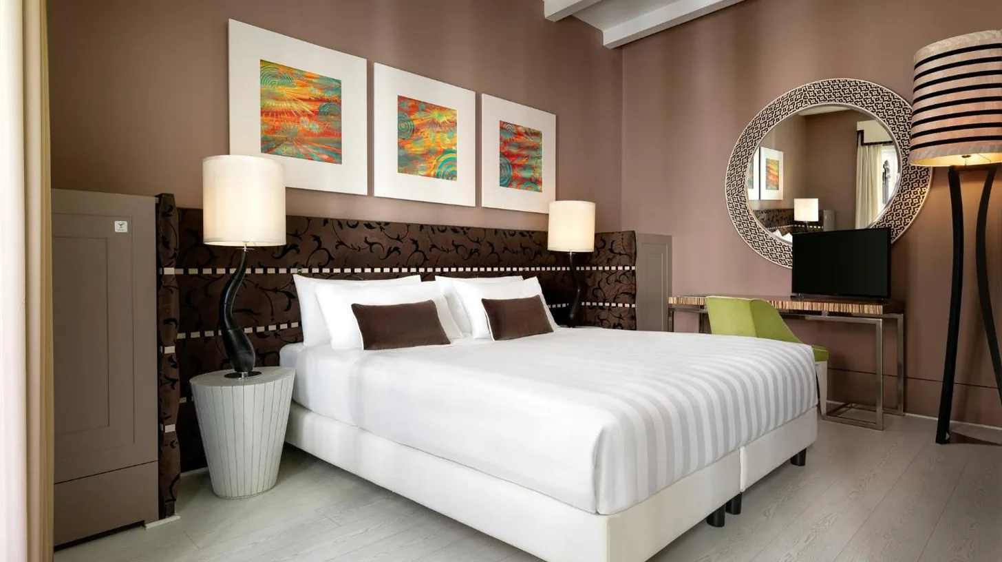 a bedroom with a white bed and a mirror at Sina Centurion Palace in Venice