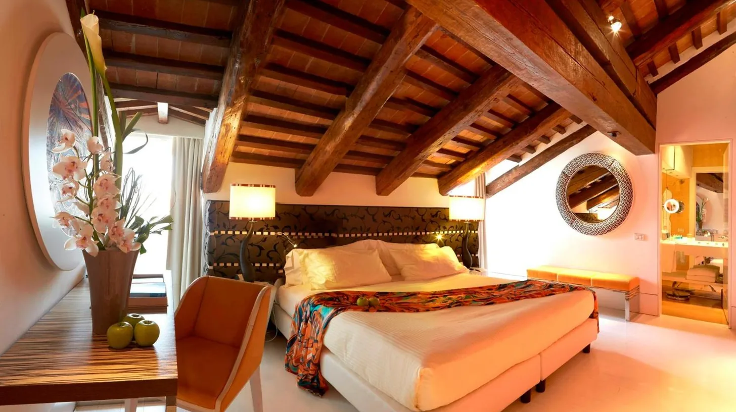 a bedroom with a bed and a table and a chair at Sina Centurion Palace in Venice