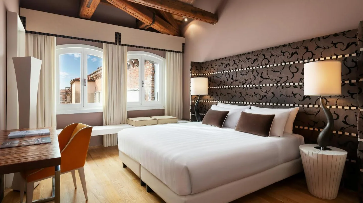 a bedroom with a bed and a table and a mirror at Sina Centurion Palace in Venice