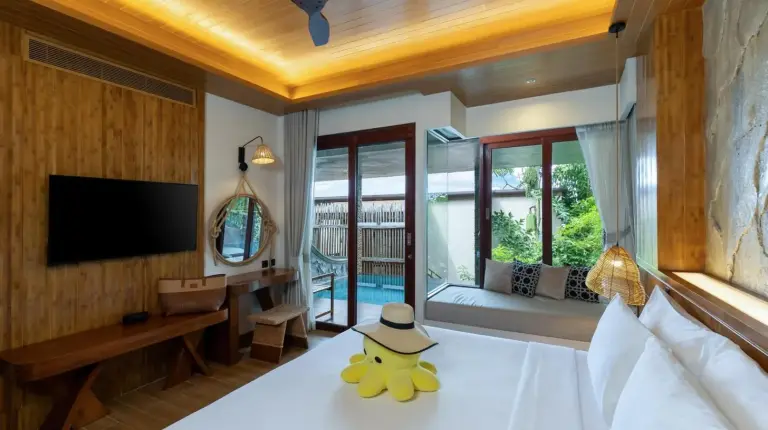 a bedroom with a bed with a hat on it at SINAE Phuket Luxury Hotel in Phuket Town