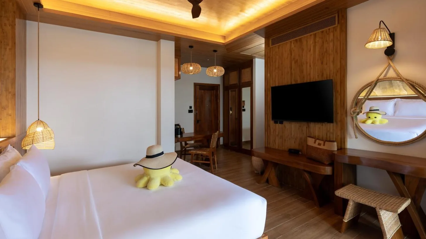 a bedroom with a white bed and a television at SINAE Phuket Luxury Hotel in Phuket Town