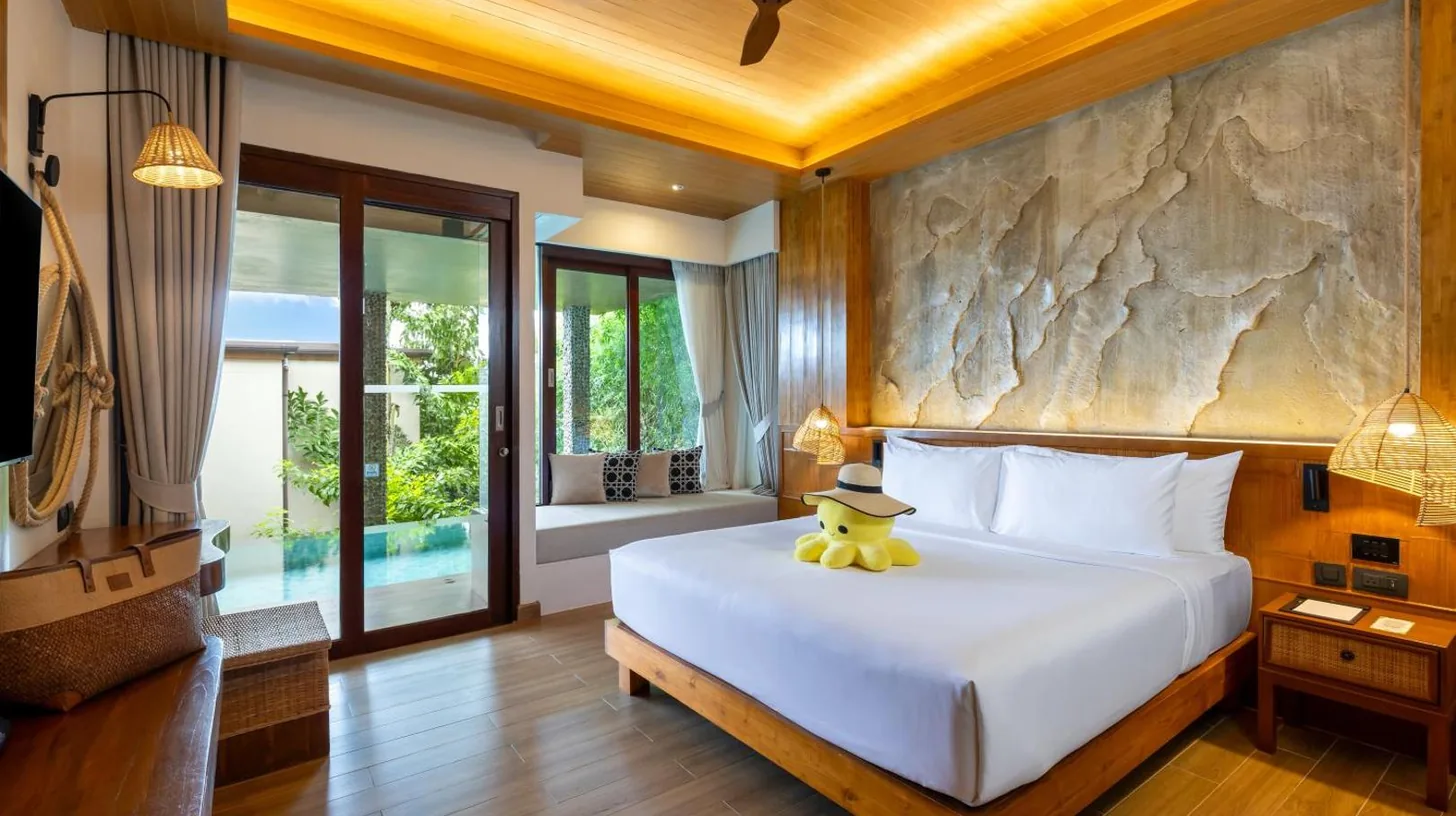 a bedroom with a bed with a teddy bear on it at SINAE Phuket Luxury Hotel in Phuket Town