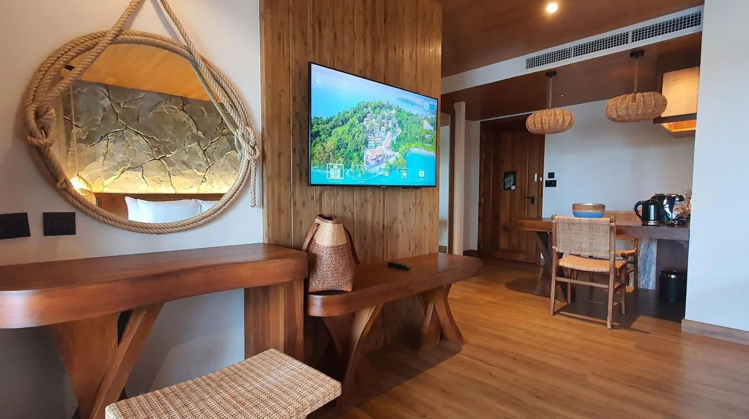 a living room with a tv on a wall at SINAE Phuket Luxury Hotel in Phuket Town