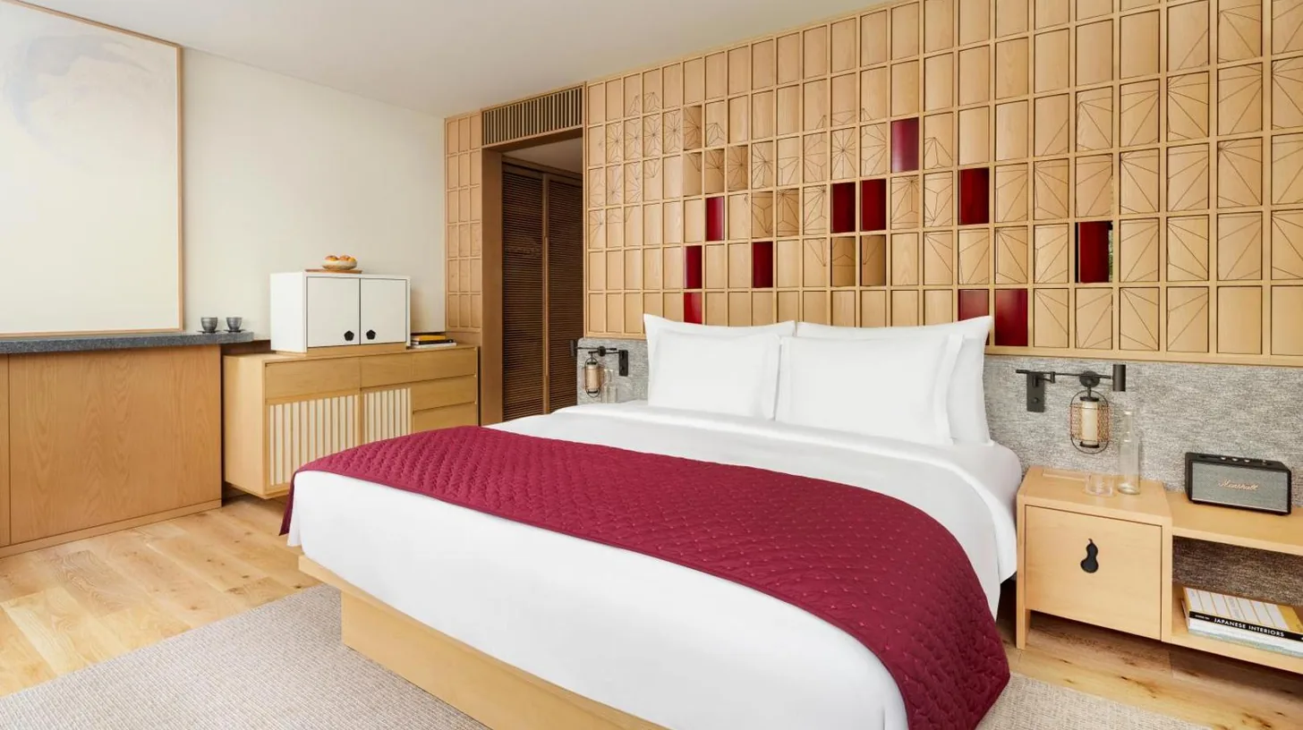 a bedroom with a large bed and a kitchen at Six Senses Kyoto in Kyoto