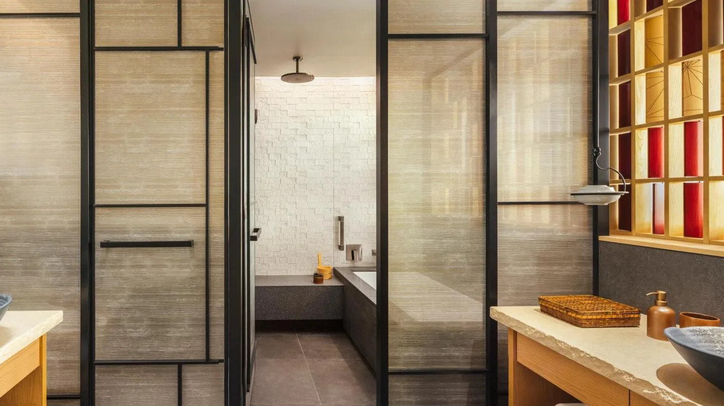 a bathroom with a glass shower door with a bath tub at Six Senses Kyoto in Kyoto
