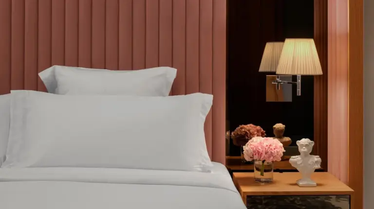 ein Schlafzimmer mit einem weißen Bett und einem Tisch mit Blumen im SLS Dubai Hotel & Residences in Dubai