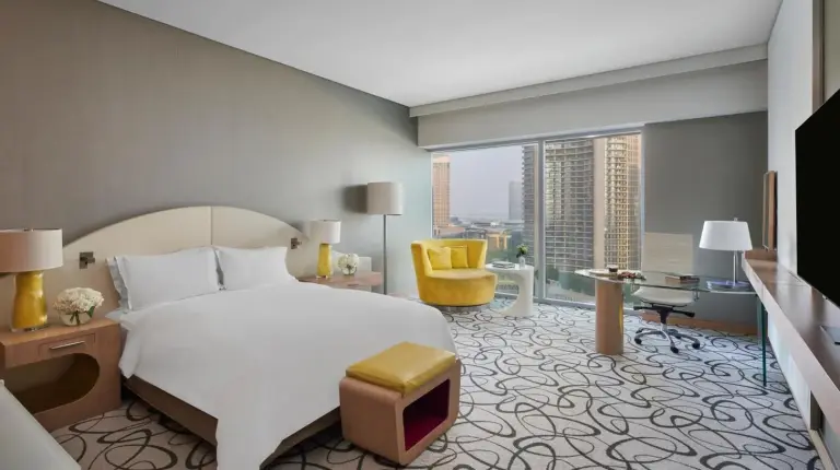 a hotel room with two beds and a television at Sofitel Dubai Downtown in Dubai