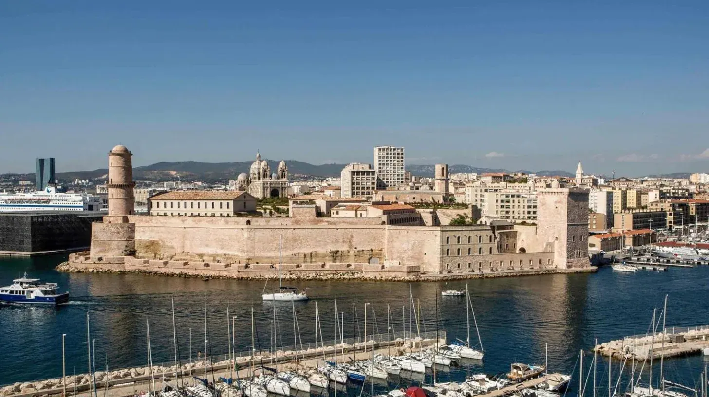 a city with boats docked in a harbor at Sofitel Marseille Vieux-Port in Marseille