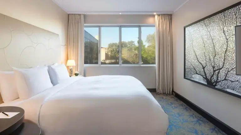 a large white bed in a room with a large window at Sofitel Marseille Vieux-Port in Marseille