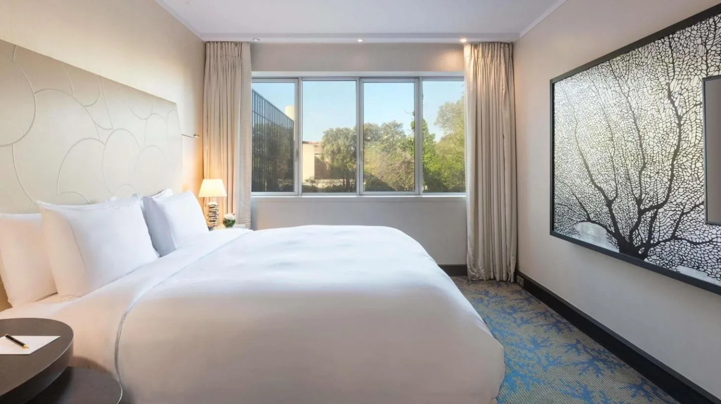 a large white bed in a room with a large window at Sofitel Marseille Vieux-Port in Marseille