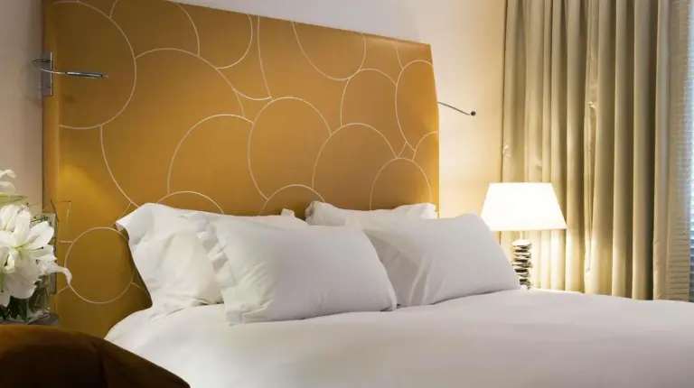 a bedroom with a white bed with a large headboard at Sofitel Marseille Vieux-Port in Marseille