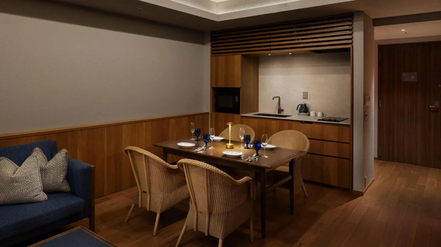 a dining room with a table and a blue couch at Southwest Grand Hotel in Naha