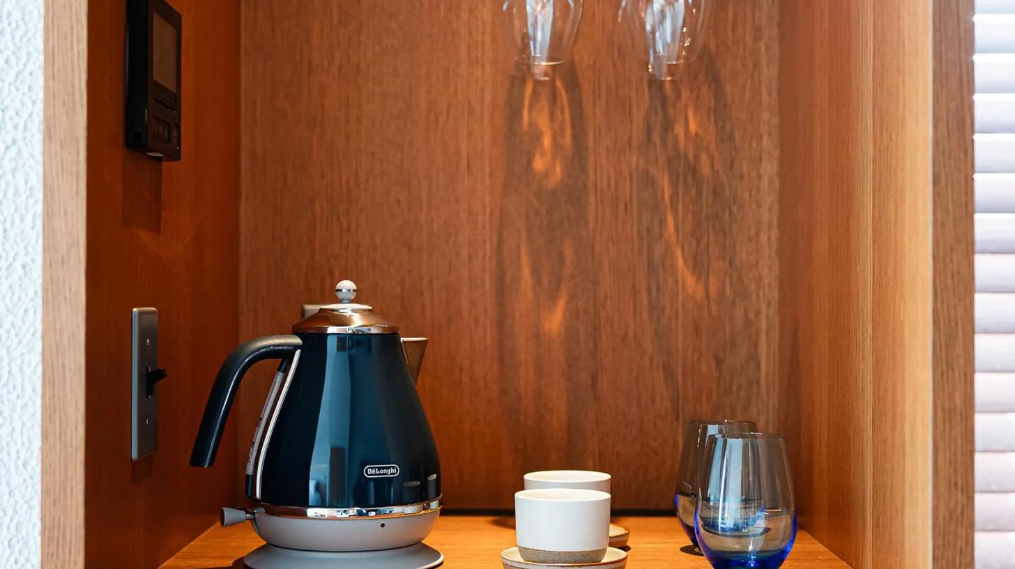 a tea kettle and a glass on a wooden shelf at Southwest Grand Hotel in Naha