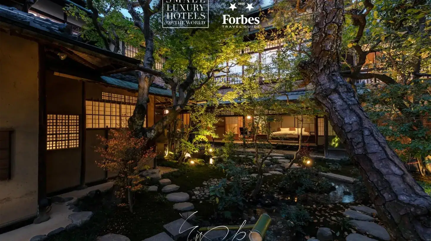 a garden with a tree in front of a building at Sowaka in Kyoto