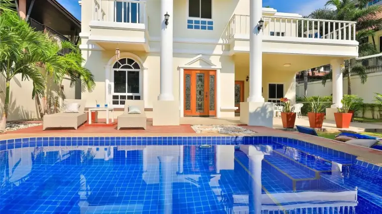 a white house with a porch and a balcony at Sweet Villas Pattaya in Pattaya South