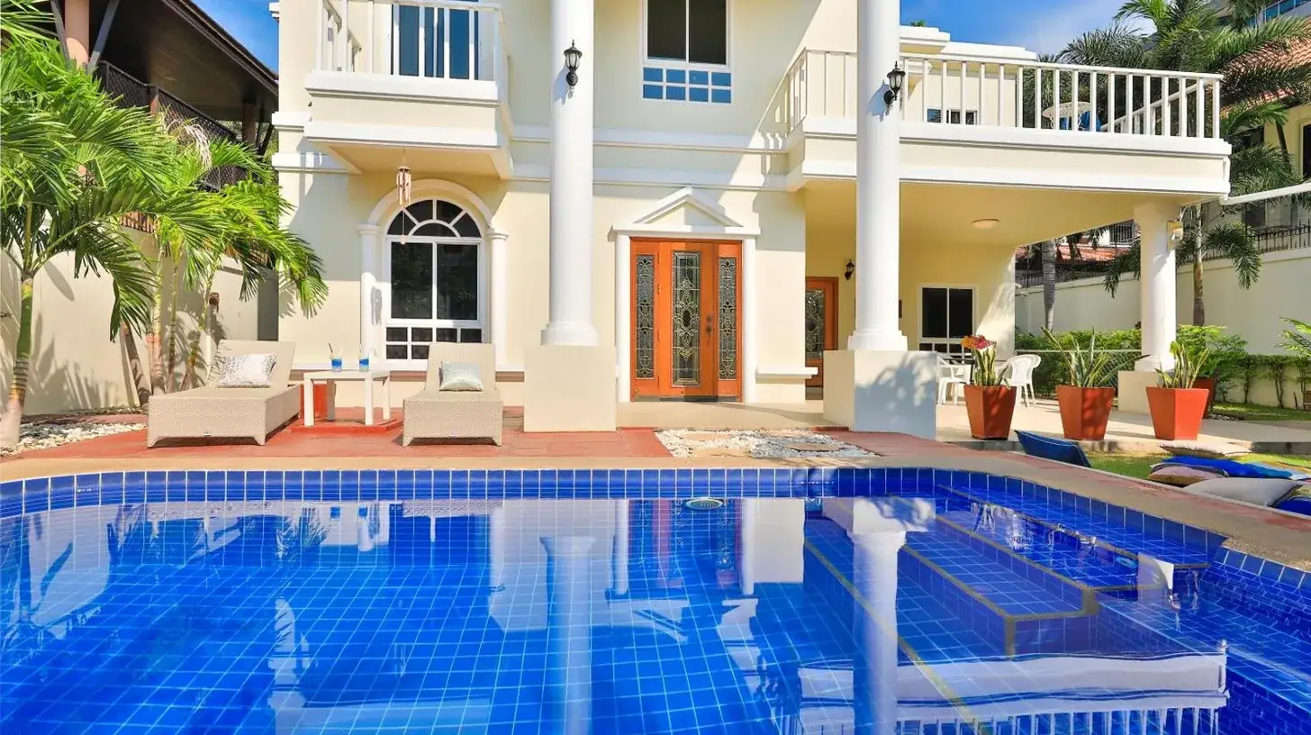 a white house with a porch and a balcony at Sweet Villas Pattaya in Pattaya South