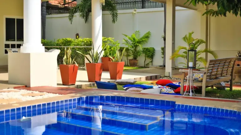 two chairs and a table next to a swimming pool at Sweet Villas Pattaya in Pattaya South