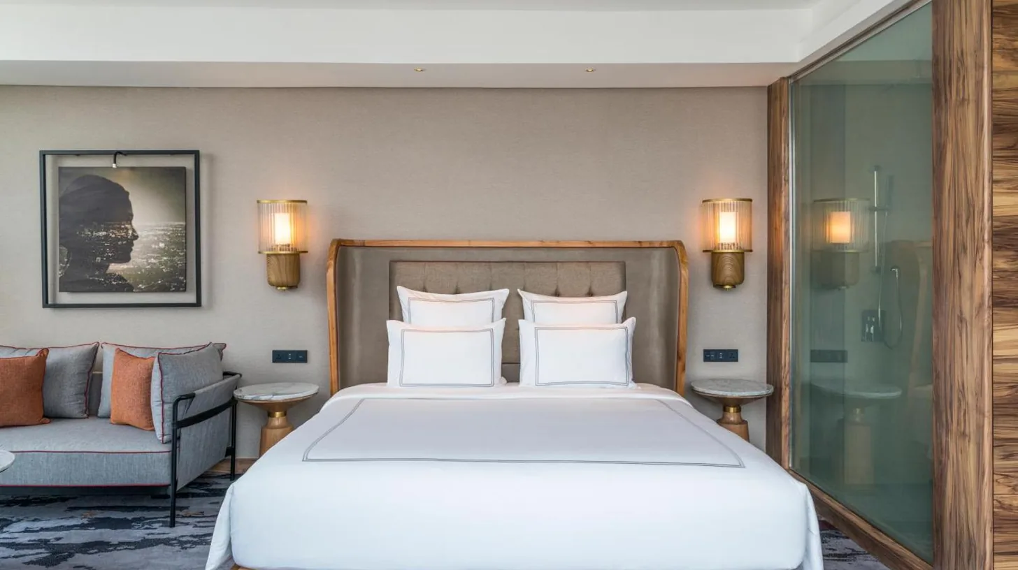 un dormitorio con una cama grande y un sofá en Swissôtel Jakarta PIK Avenue en Yakarta