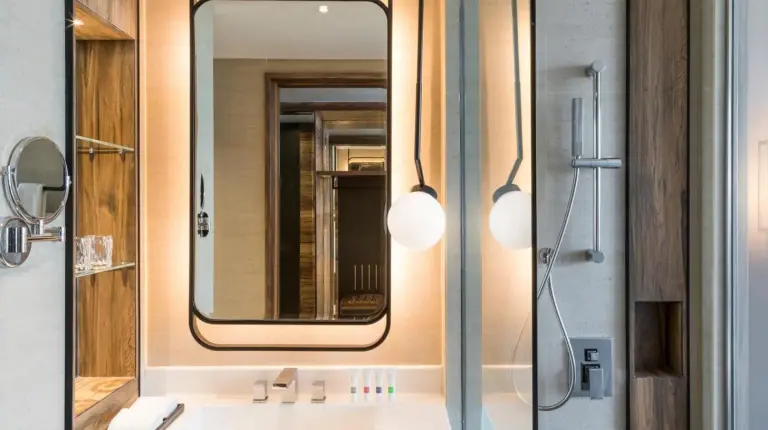 una habitación de hotel con una cama, un escritorio y ventanas en Swissôtel Jakarta PIK Avenue en Yakarta