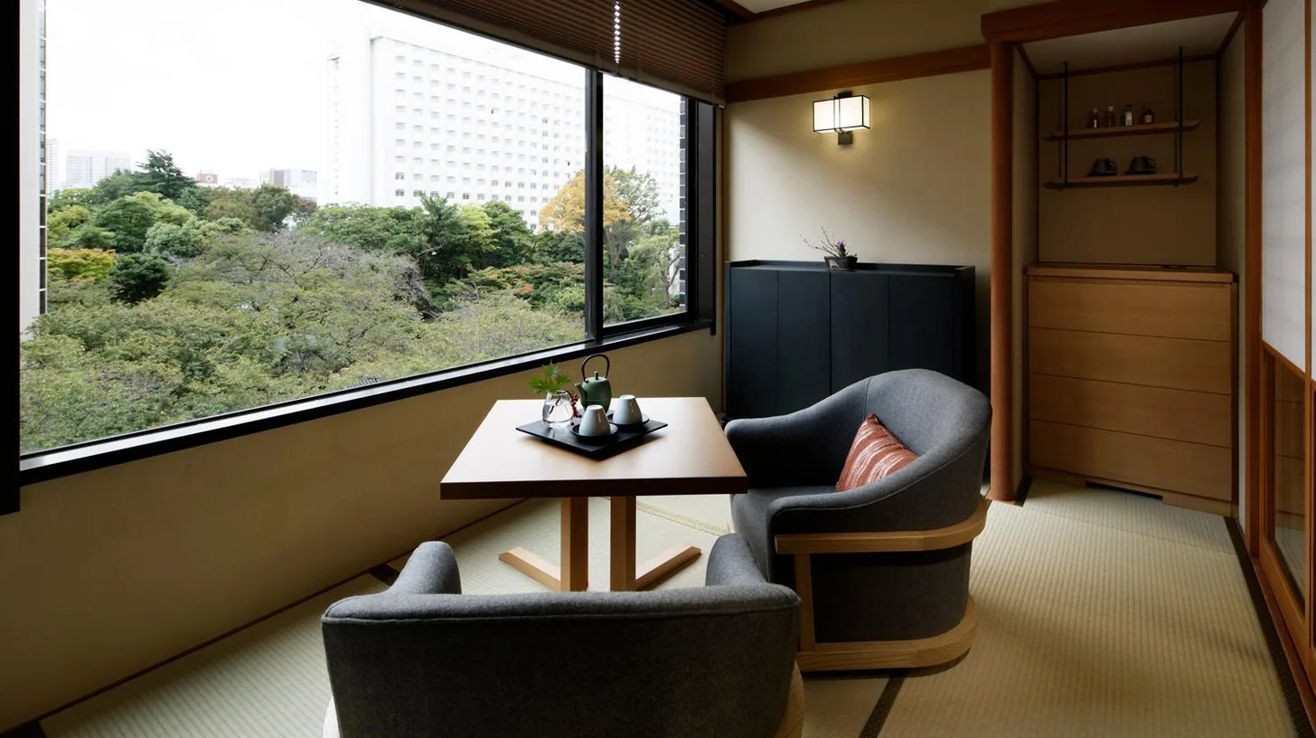 a room with two chairs and a table and a tv at Takanawa Hanakohro