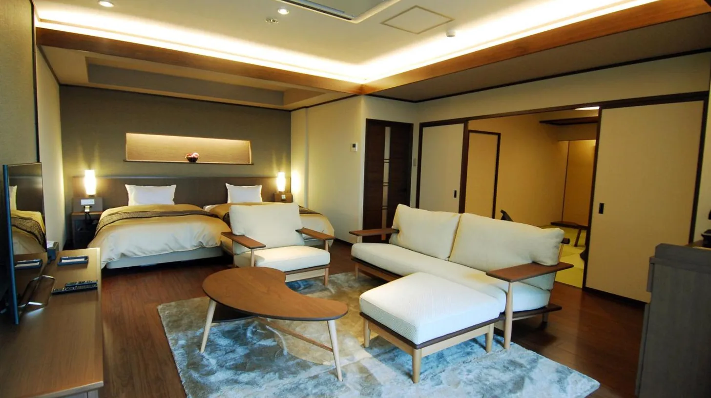 une chambre d'hôtel avec un lit et un salon à Taketoritei Maruyama à Arima Onsen à Kobe